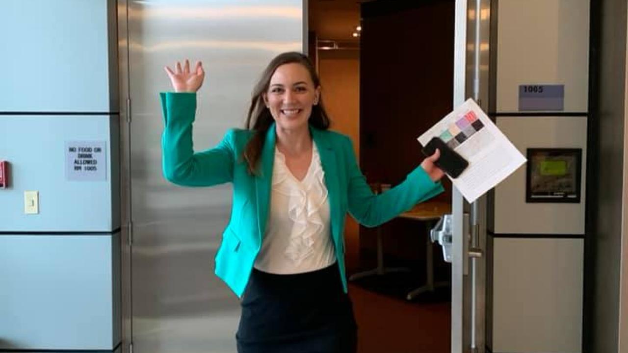 Jackie exits the lecture hall where she defended her dissertation defense